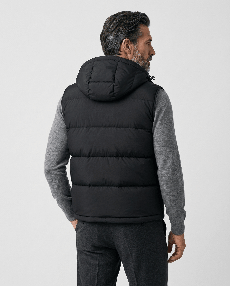 Back view of black quilted vest with hood, worn over a gray knit sweater