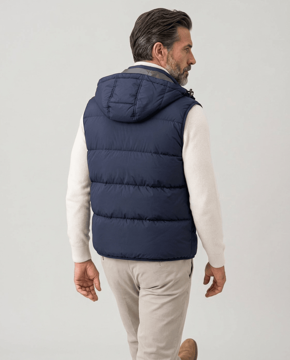 Back view of navy quilted vest with hood over a cream sweater and beige trousers