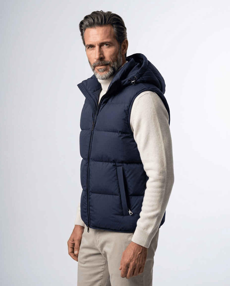 Navy hooded quilted vest in an angled studio pose over a cream sweater and beige trousers