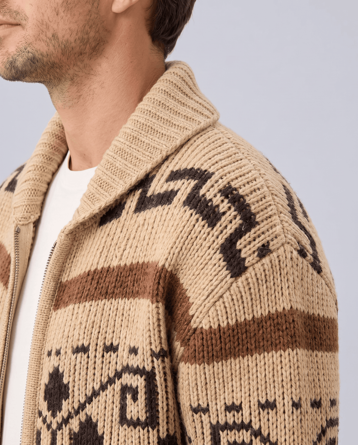 Close view of khaki cardigan shawl collar and geometric jacquard pattern on the chest