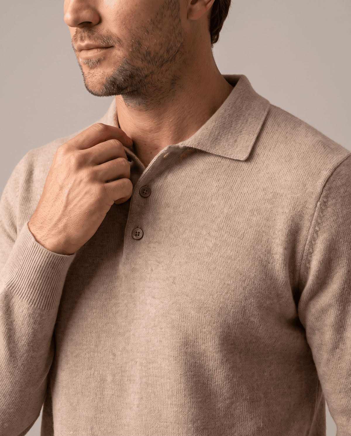 Hand on the button placket of the Elias khaki wool knit polo sweater