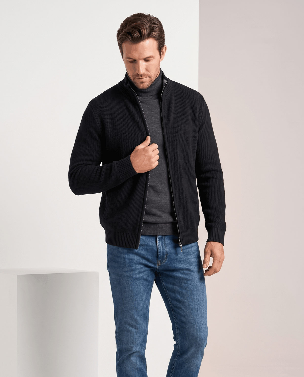 Black zip-up cardigan worn open over a gray tee with blue jeans