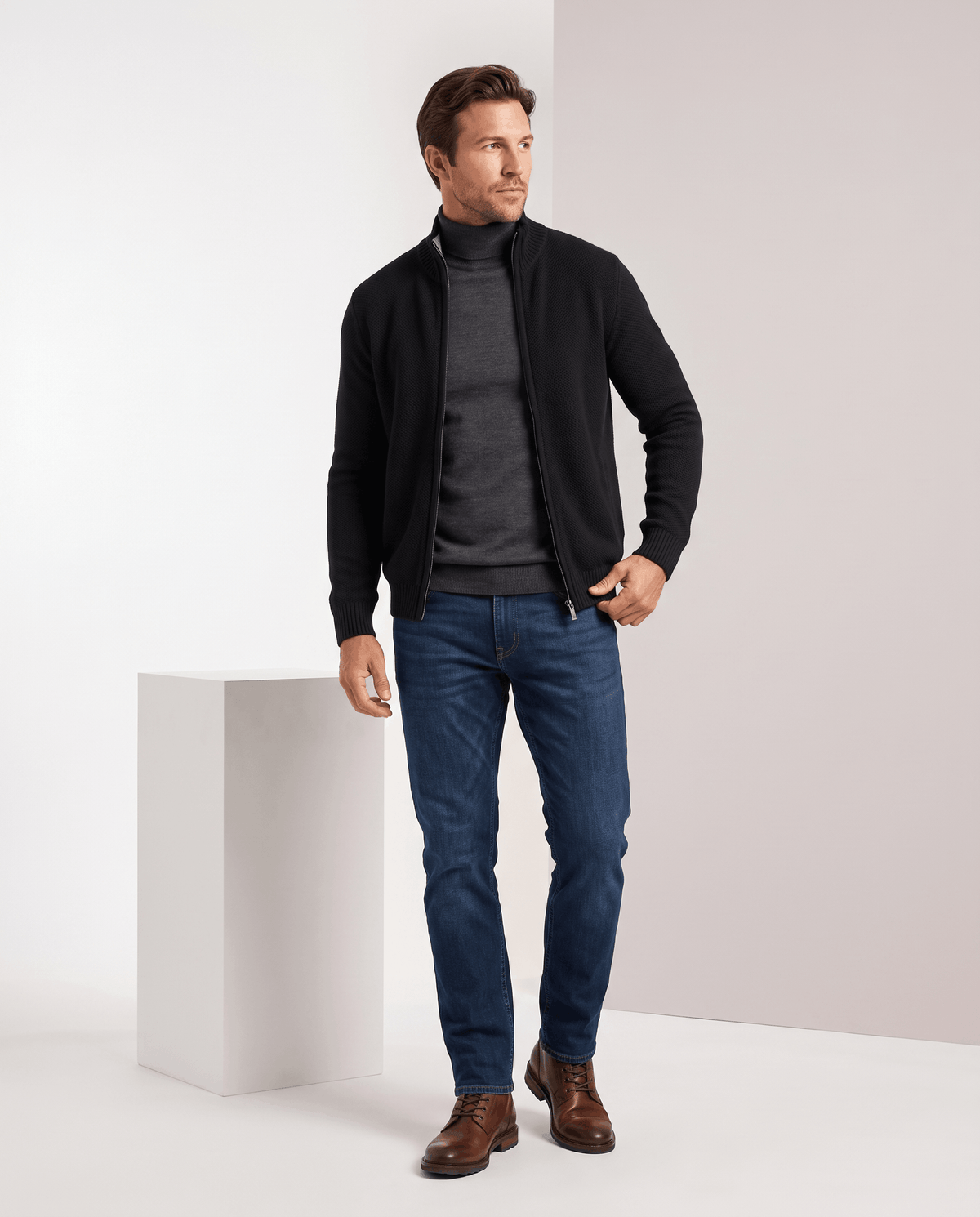 Full-length view of the black cardigan with gray turtleneck, jeans and brown shoes