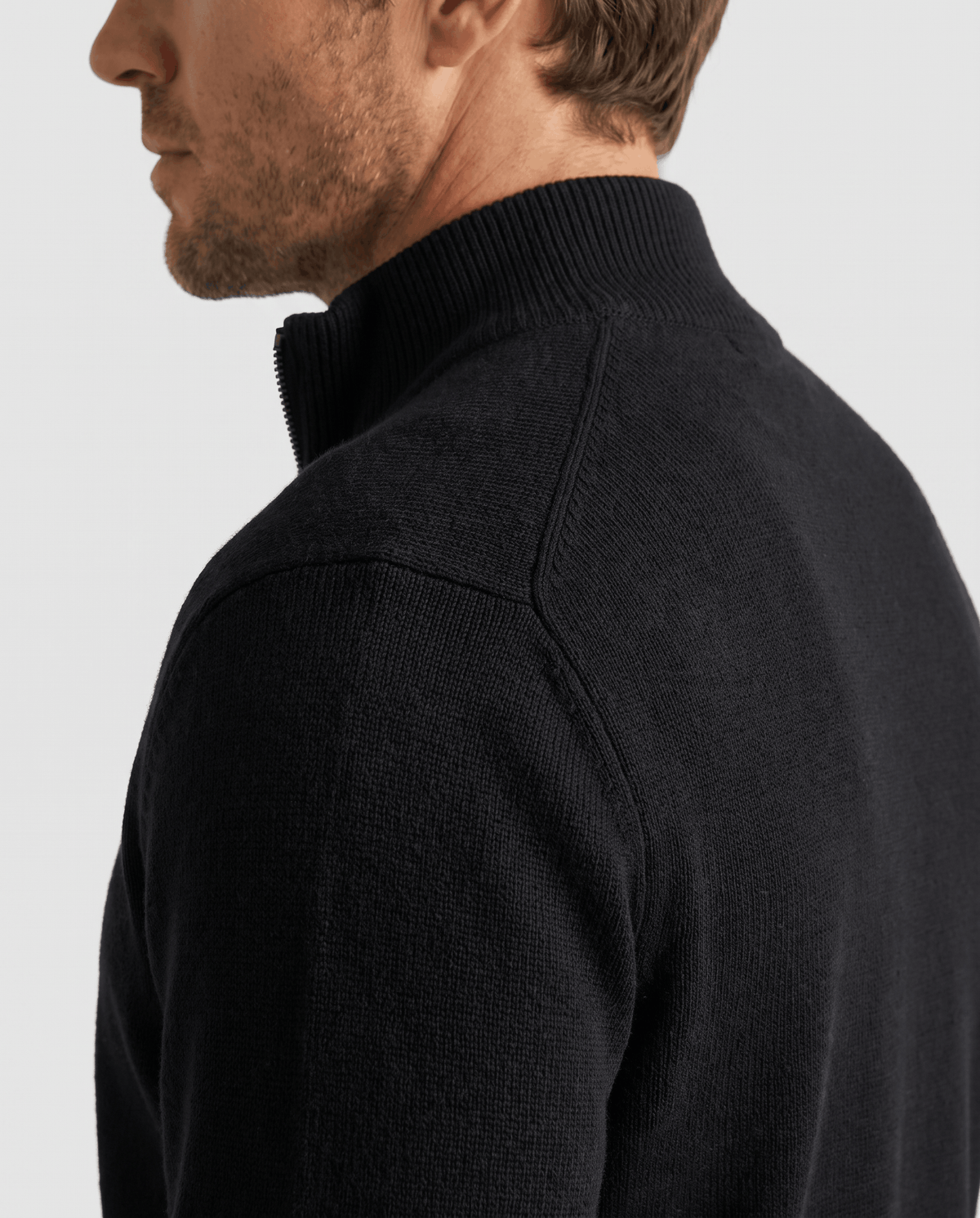Side profile of the black cardigan showing the ribbed stand collar