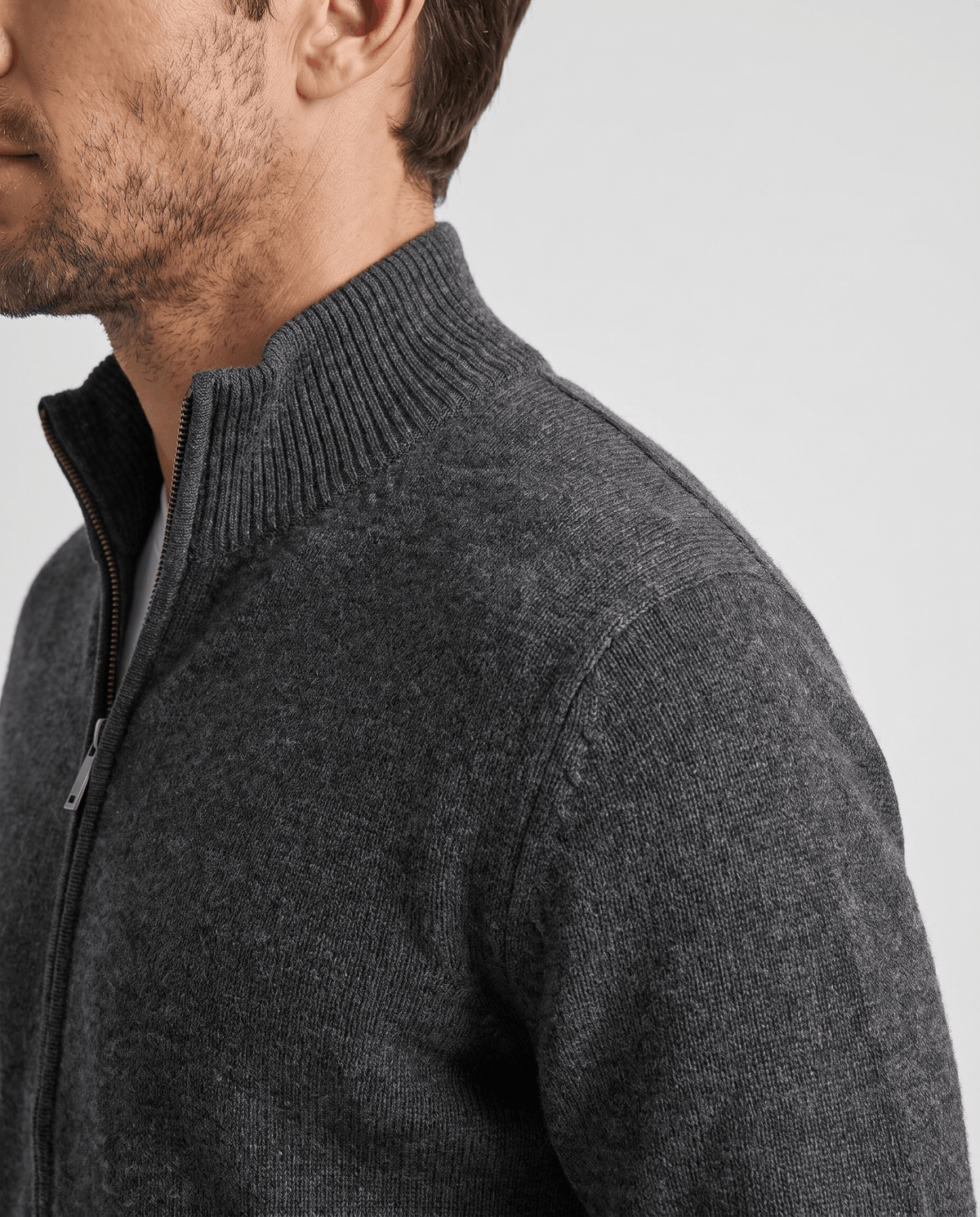 Side profile of the dark gray cardigan showing the stand collar and marled knit