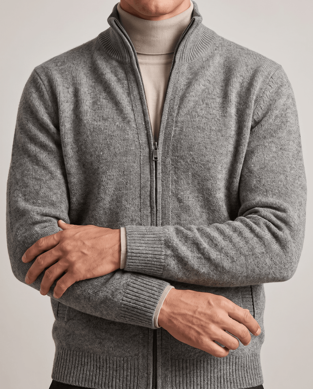 Close-up of the light gray knit cardigan with front zip over a cream turtleneck