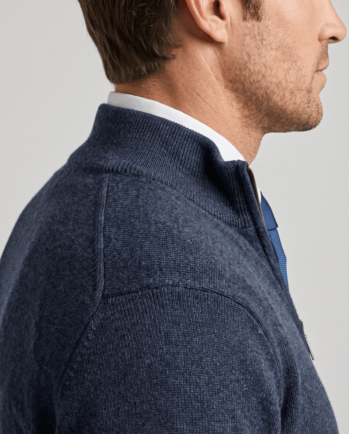 Side close-up of the navy stand collar worn over a collared shirt
