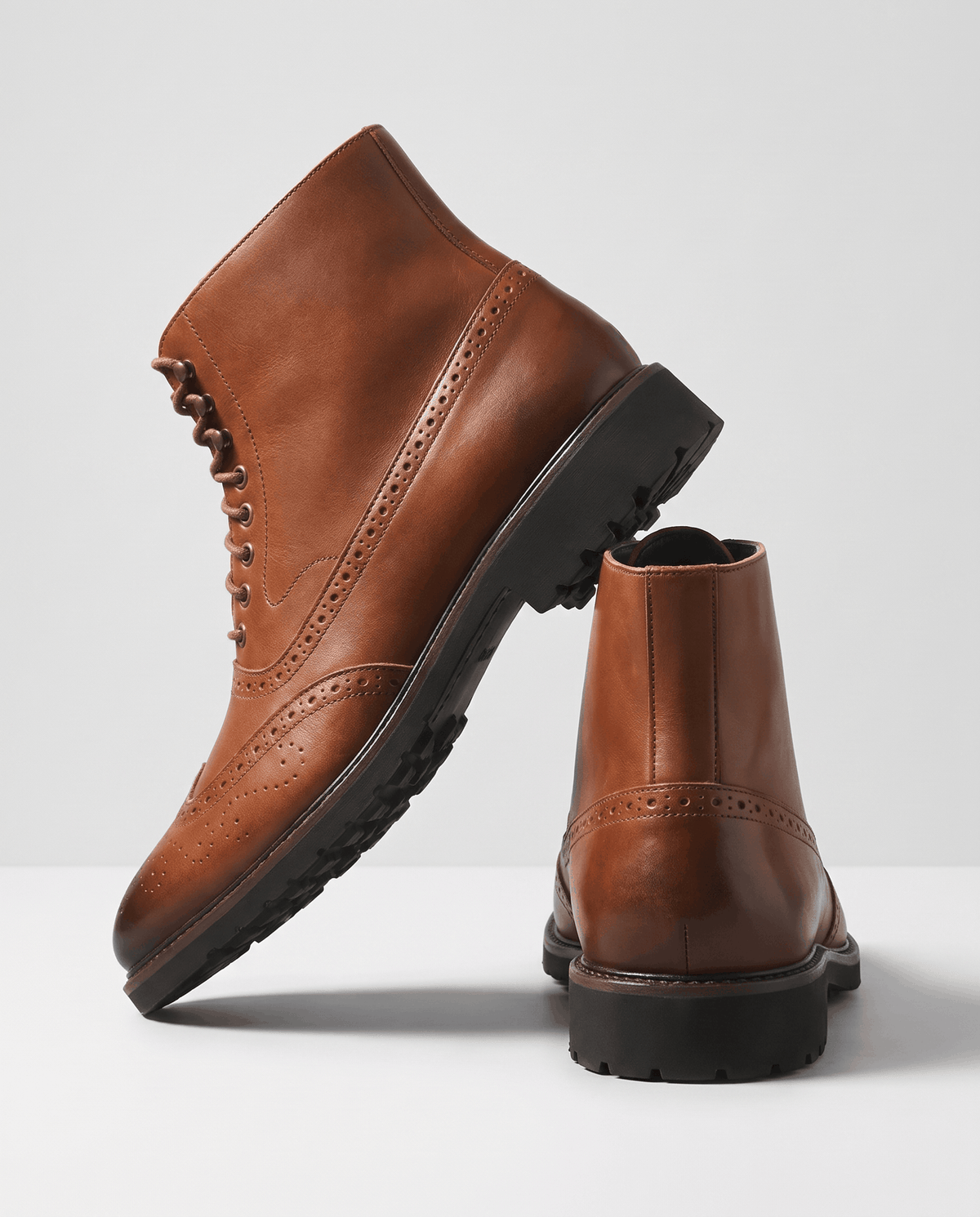 Side view of a brown leather ankle boot with a second boot behind it