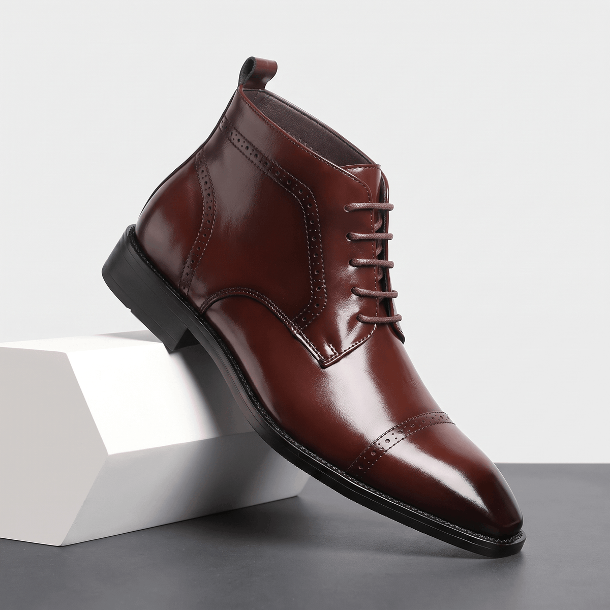 Polished dark brown leather brogue boots featuring a punched cap toe, five-eyelet lace-up closure, and slim rubber sole.