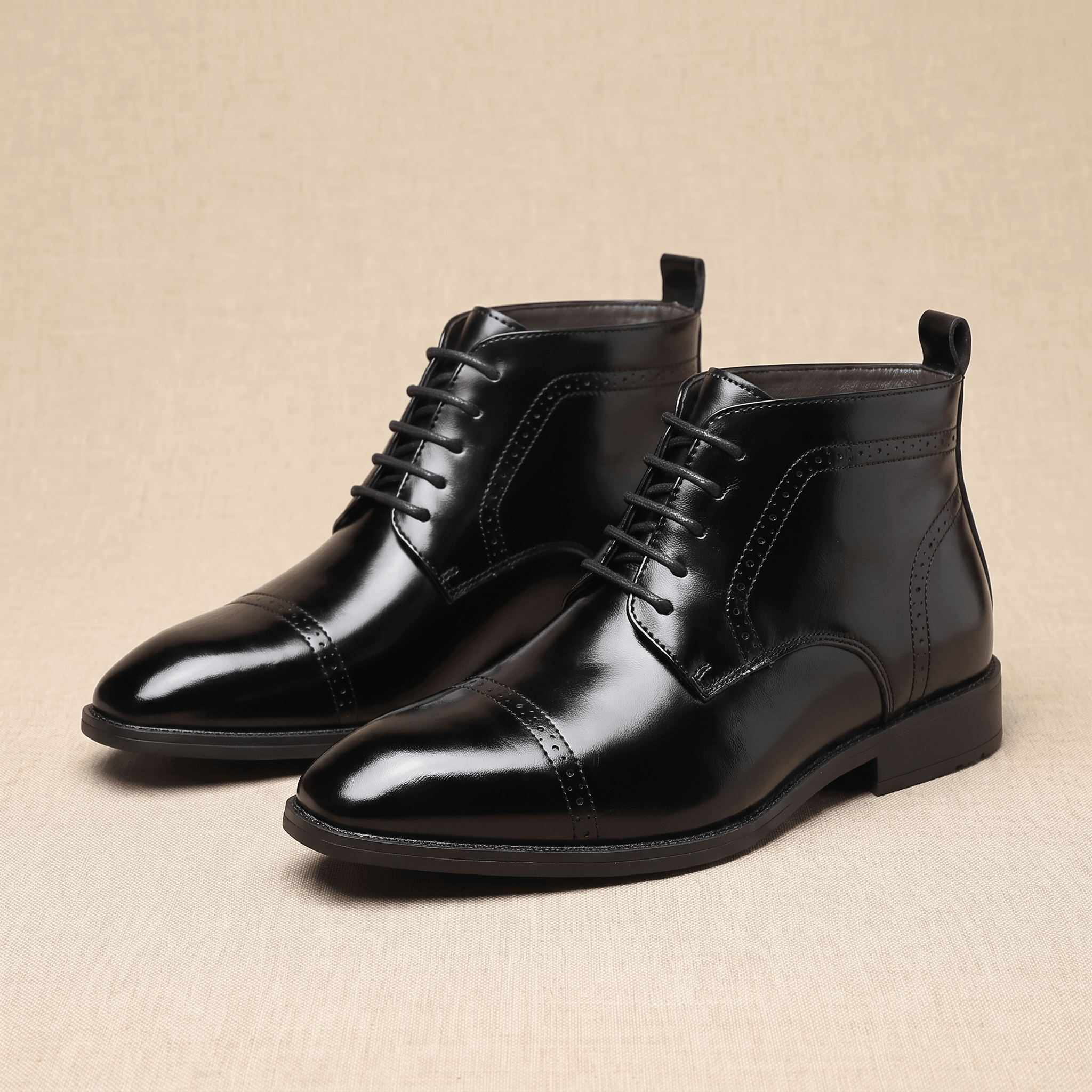 Black leather brogue boots with a punched cap toe, five-eyelet lacing, and a slim non-slip rubber sole.