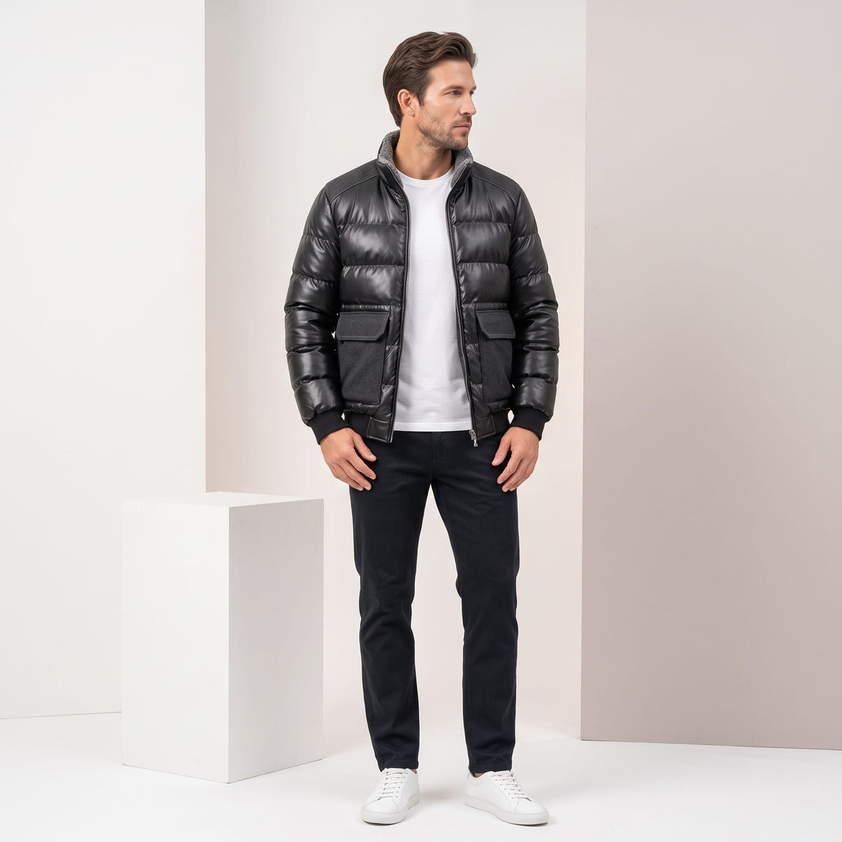 Man wearing the black leather-look bomber with dark jeans, full length view