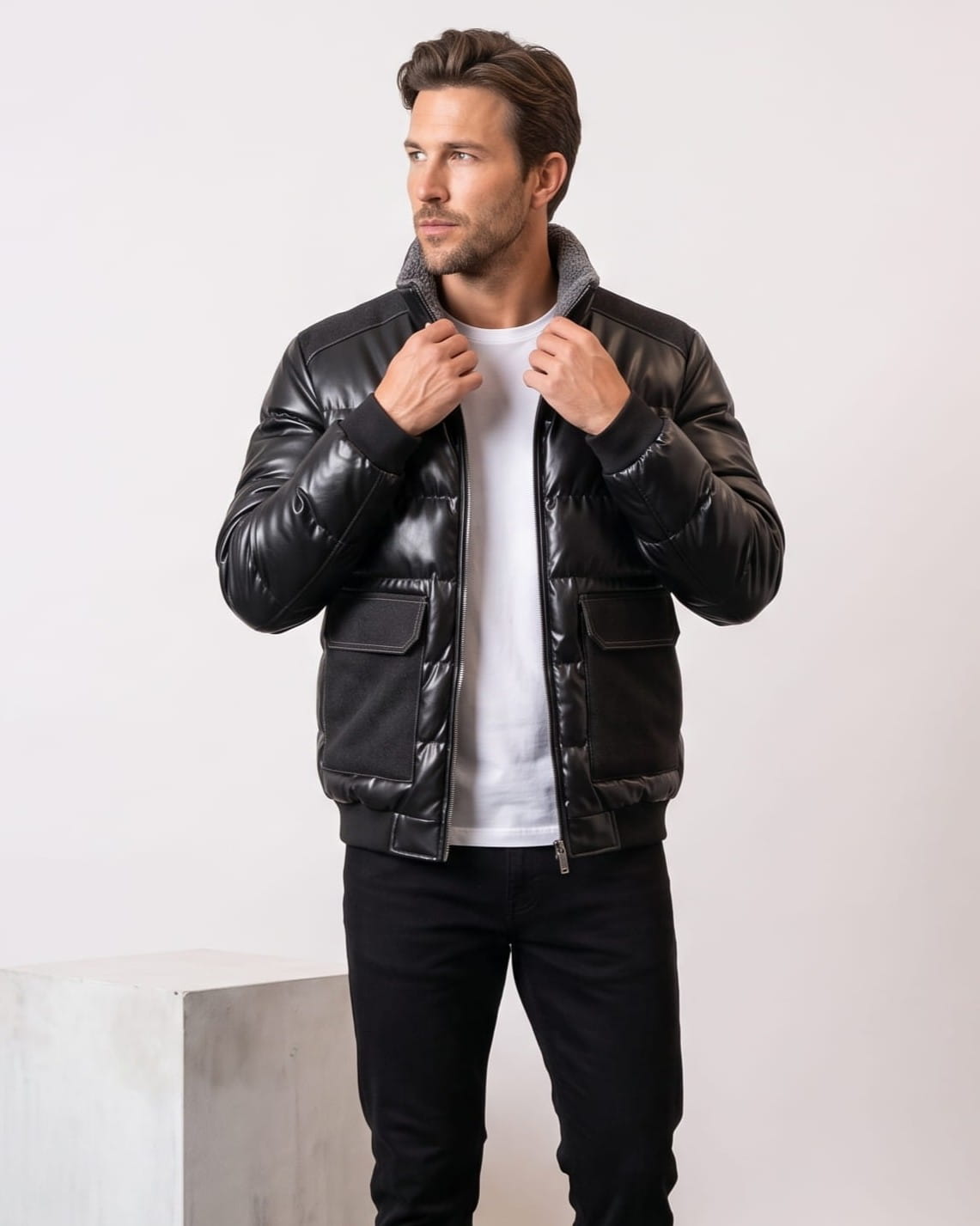 Man wearing the black leather-look puffer bomber, holding the sherpa-lined stand collar