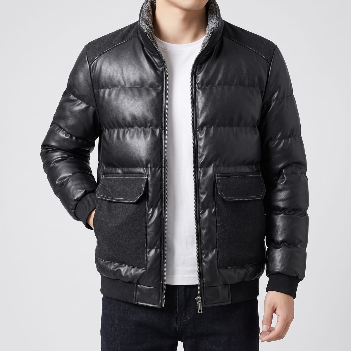 Black leather-look puffer bomber worn zipped, showing horizontal quilting and contrast flap pockets