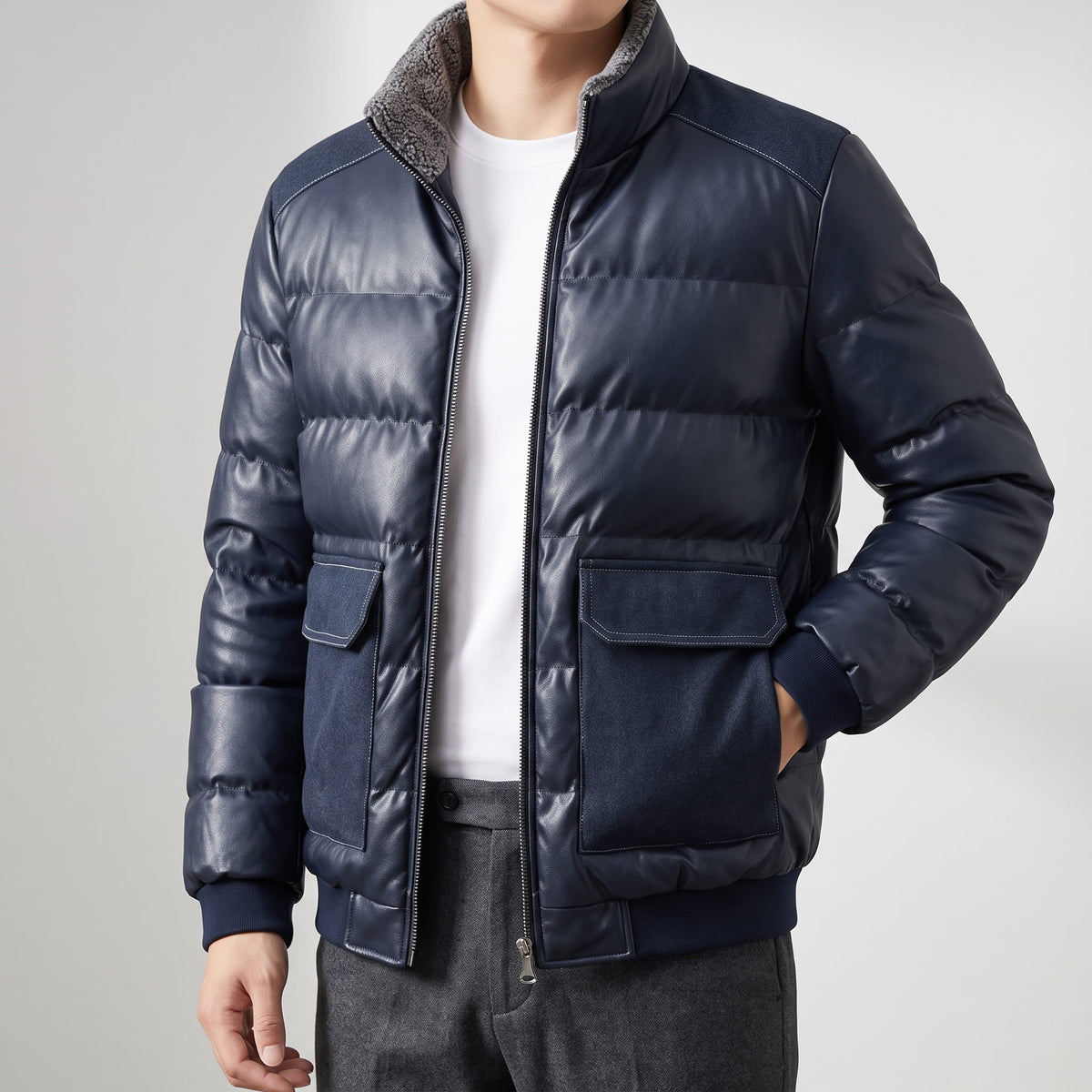 Man wearing the blue leather-look puffer bomber open over a white tee in a studio