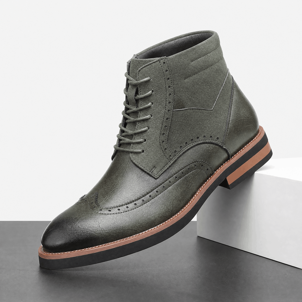 Gray leather wingtip ankle boot with a suede shaft panel, brogue detailing, burnished toe, and a stacked welted rubber sole.
