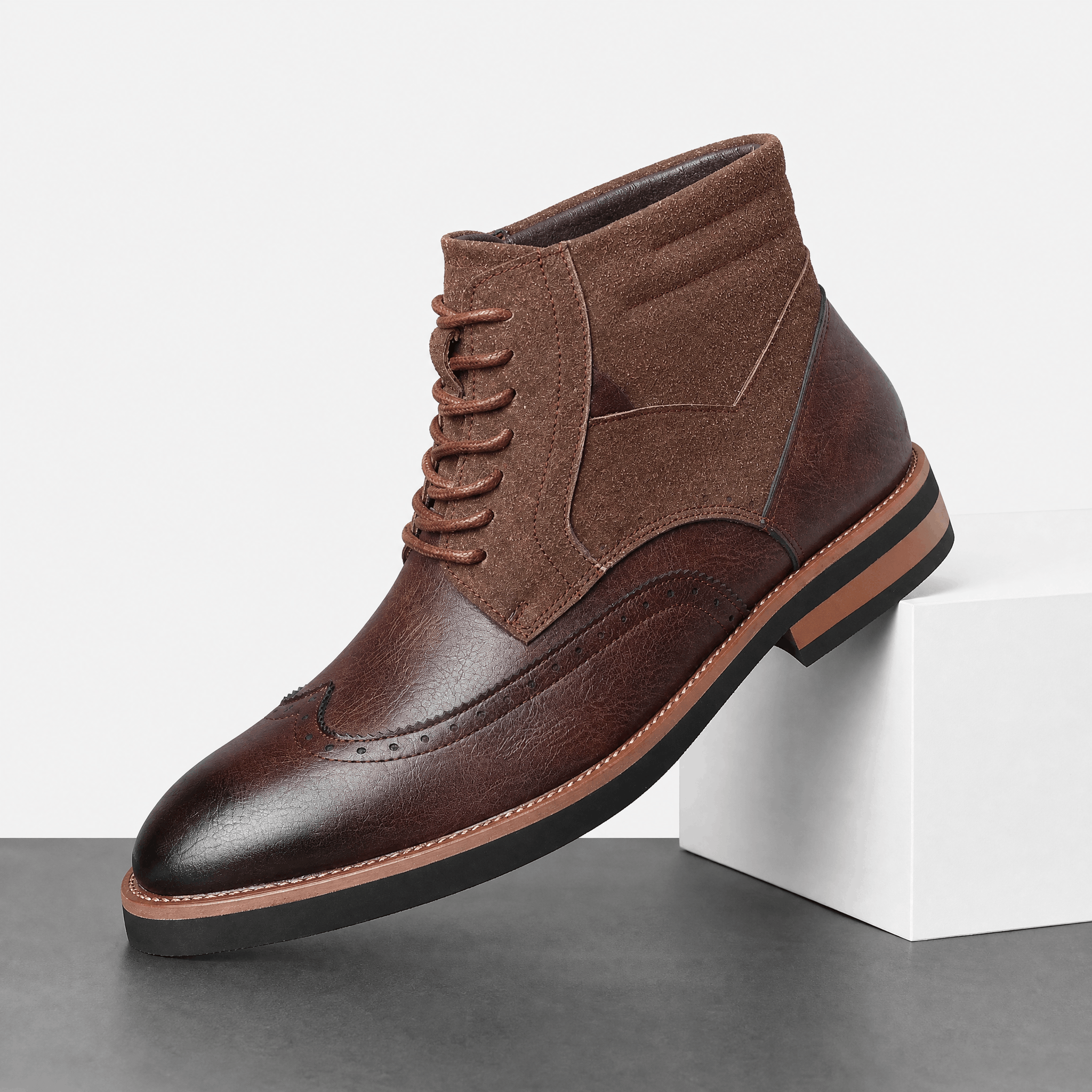 Dark brown leather wingtip ankle boot with a suede shaft panel, burnished toe, punched brogue detailing, and a welted rubber sole.