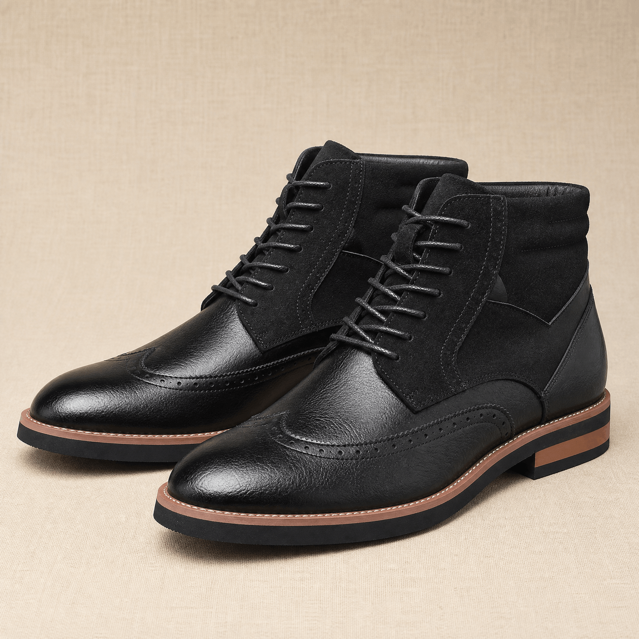 Black leather wingtip ankle boots featuring a suede shaft panel, brogue detailing, and a contrast welted rubber sole.