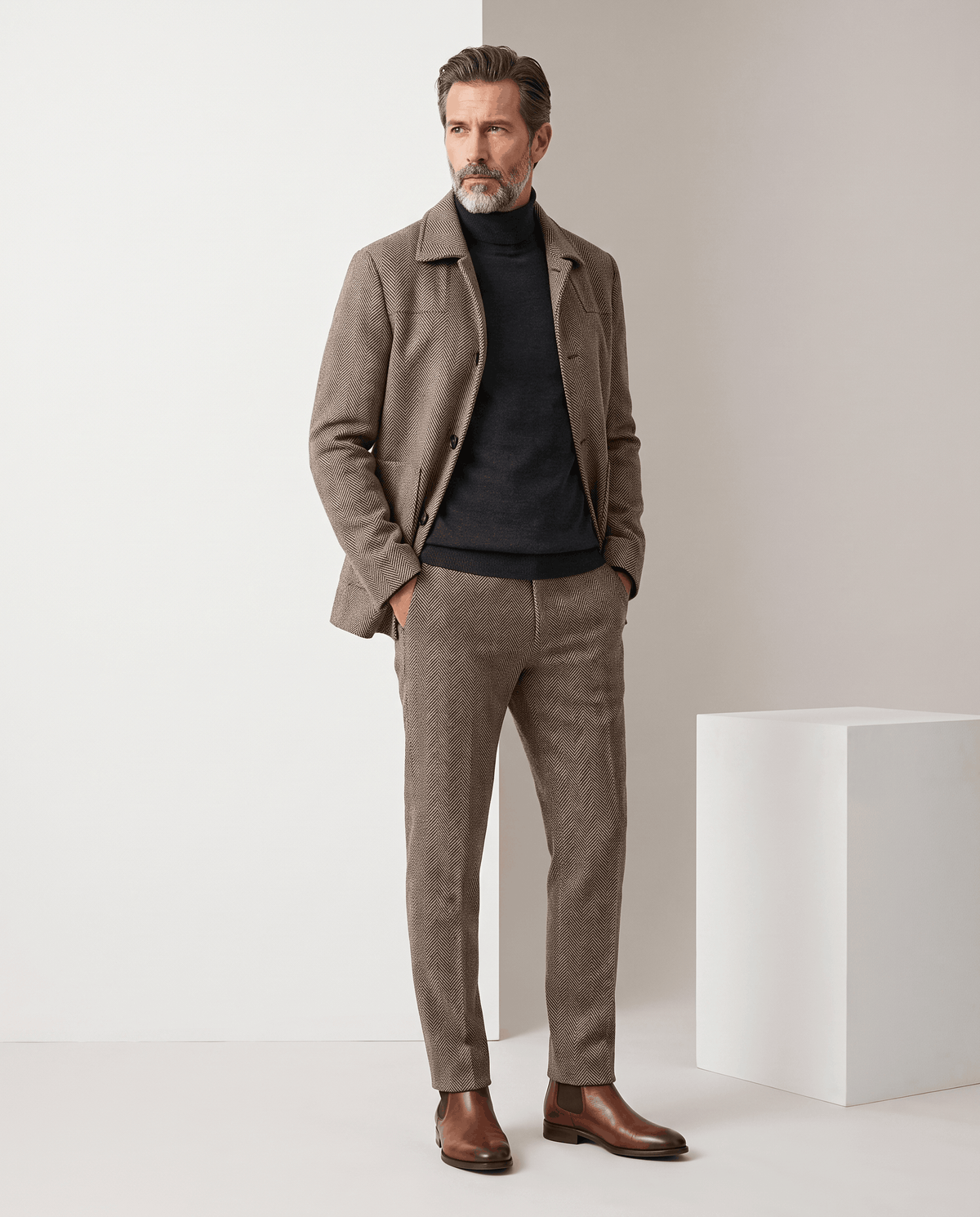Full-length view of a man wearing the Henrik light brown herringbone wool coat