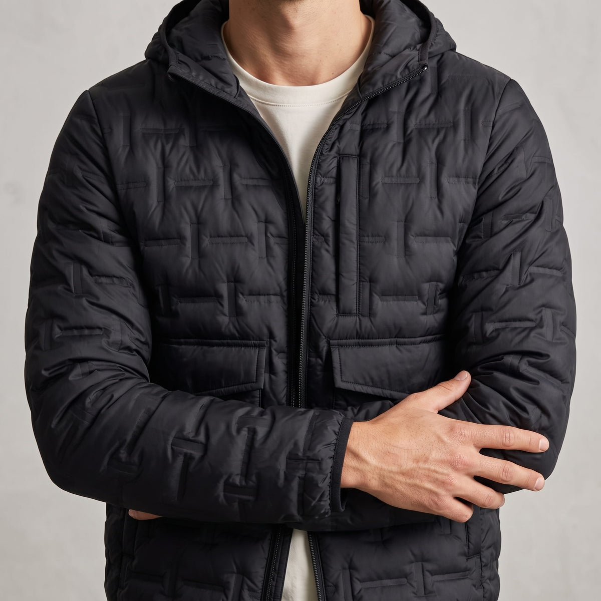 Black jacket torso showing the hood, chest flap pockets and quilting