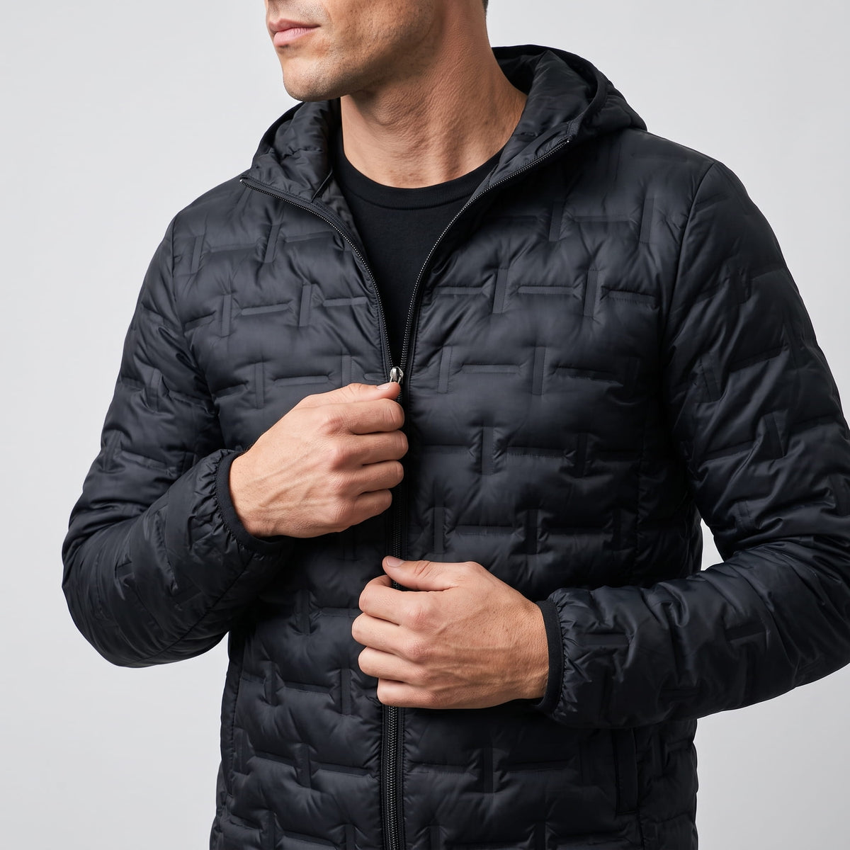 Black jacket held open at the zip, showing the hood and slim cut
