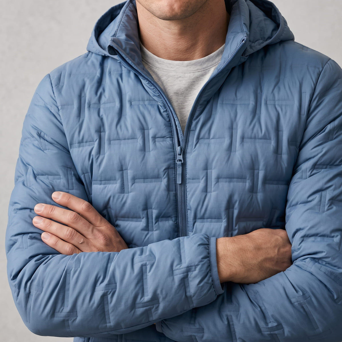 Blue torso with arms crossed, showing hood and offset quilted blocks