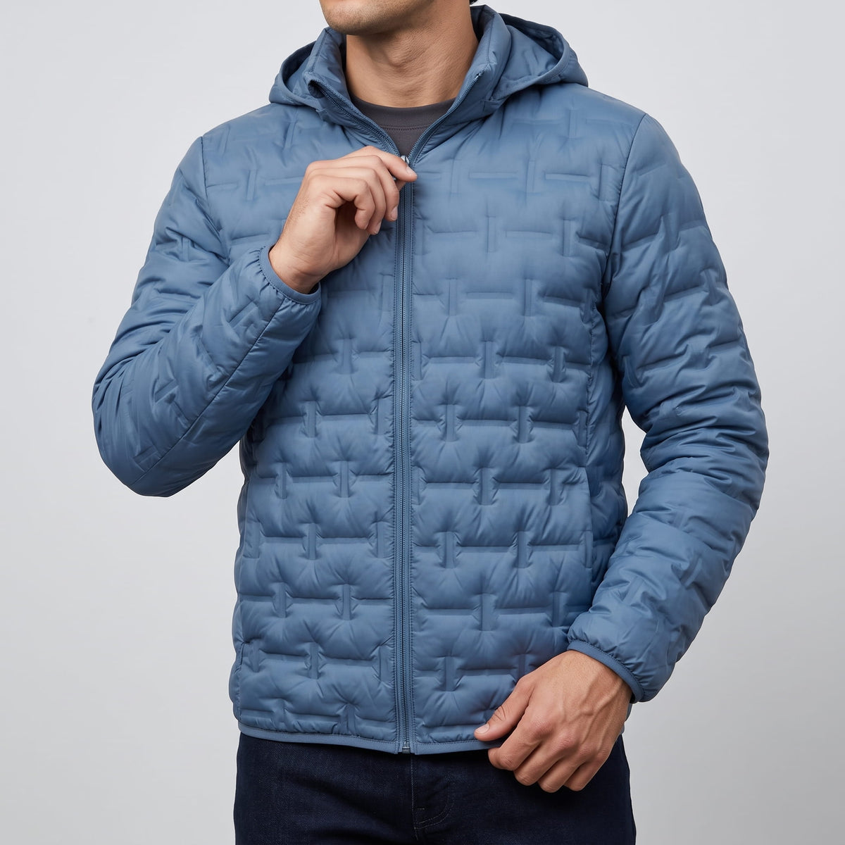 Blue jacket being zipped at the chest, hood resting behind the neck