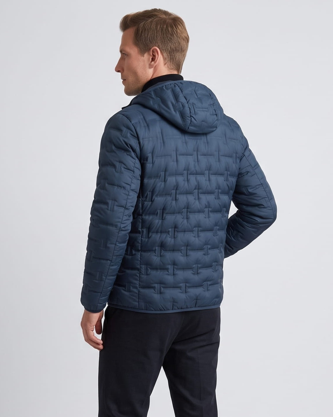 Back view of the navy jacket showing the hood and quilted panels