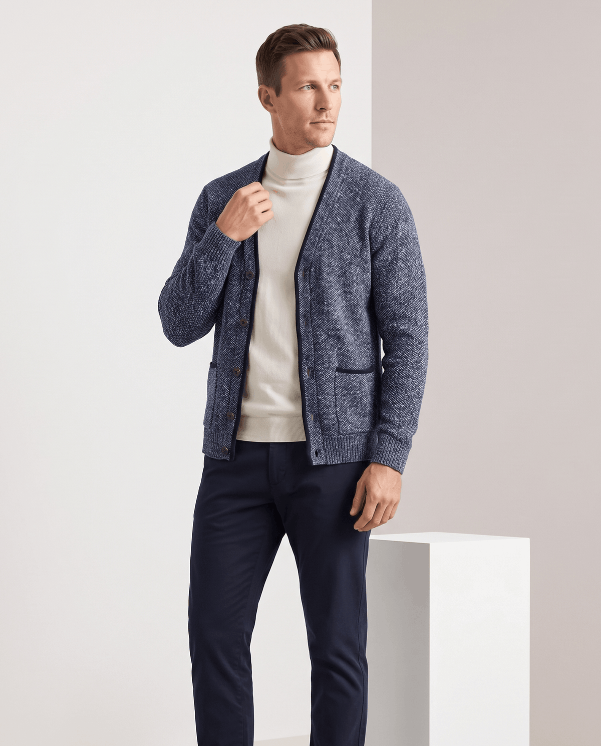 Full-length view of the blue marled cardigan over a cream turtleneck