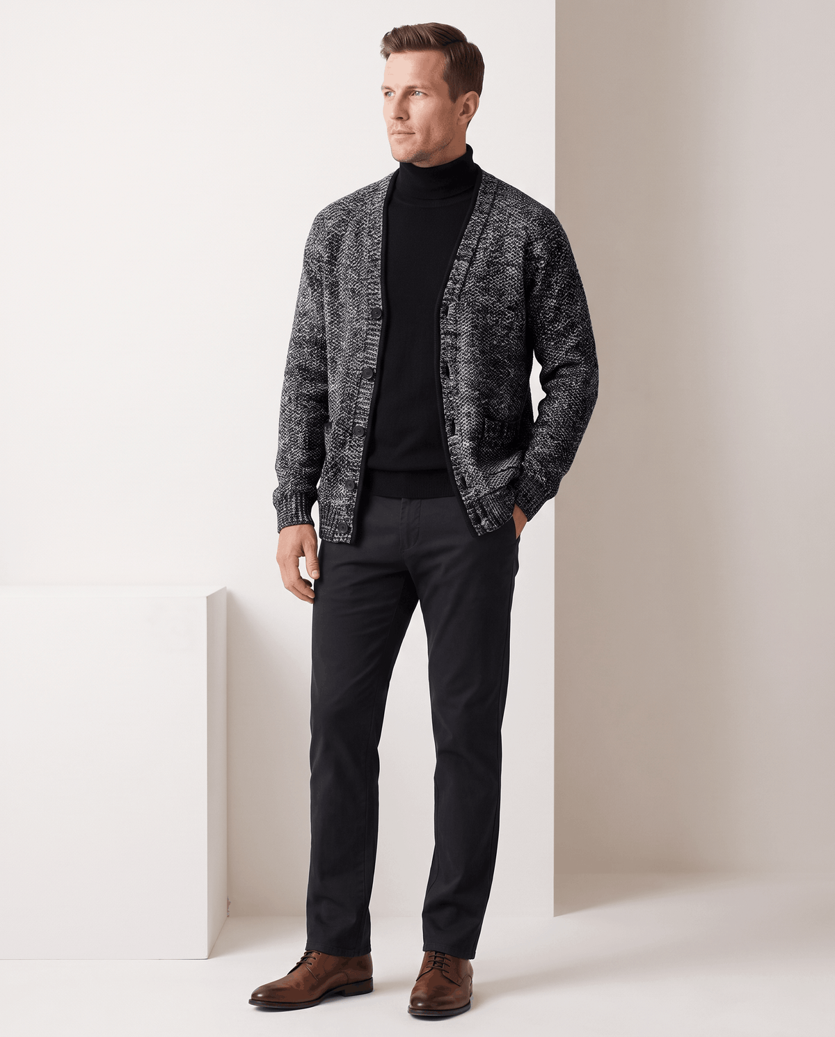 Full-length view of the dark gray cardigan over a black turtleneck with brown shoes