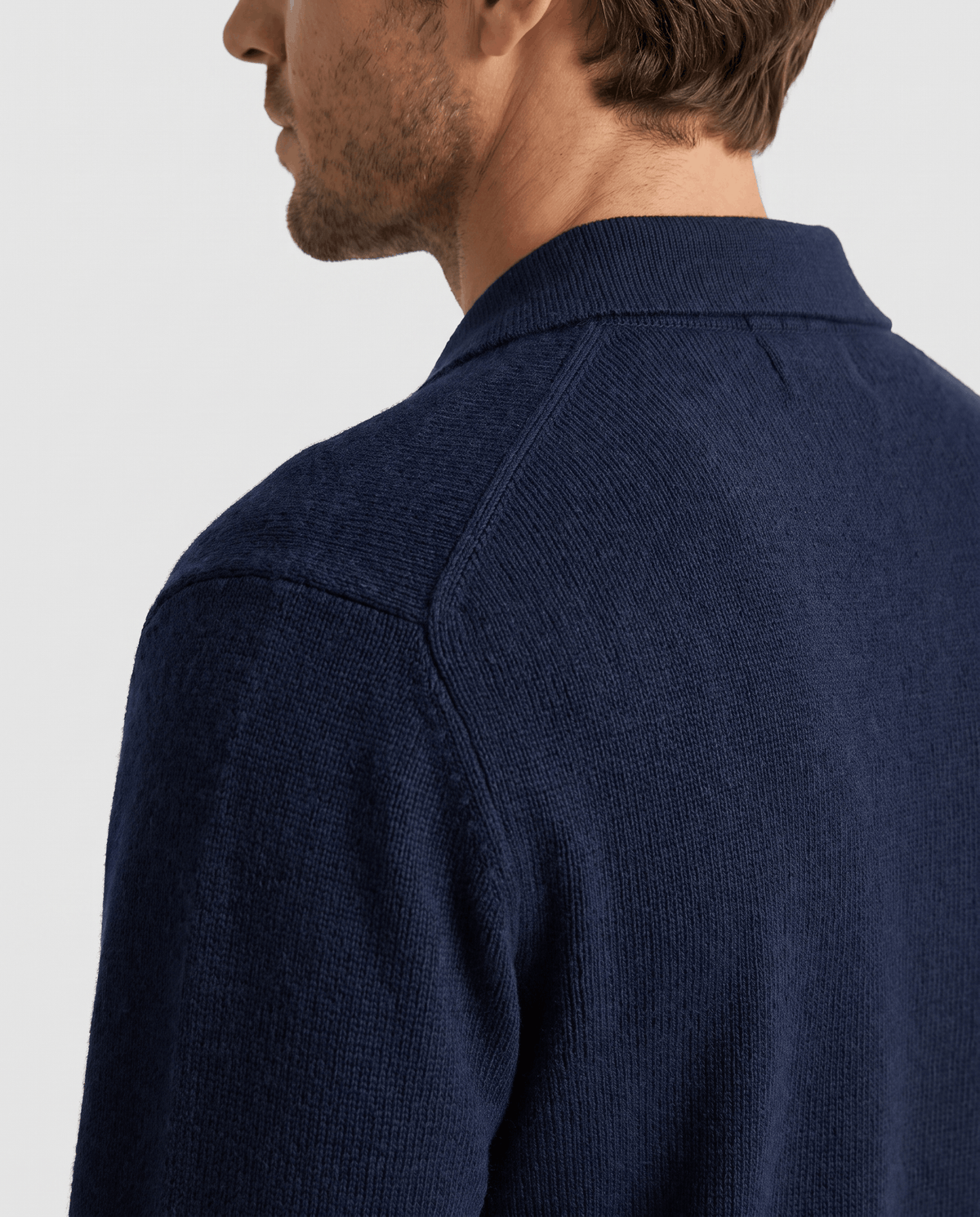 Side close-up of the navy cardigan collar and textured shoulder knit