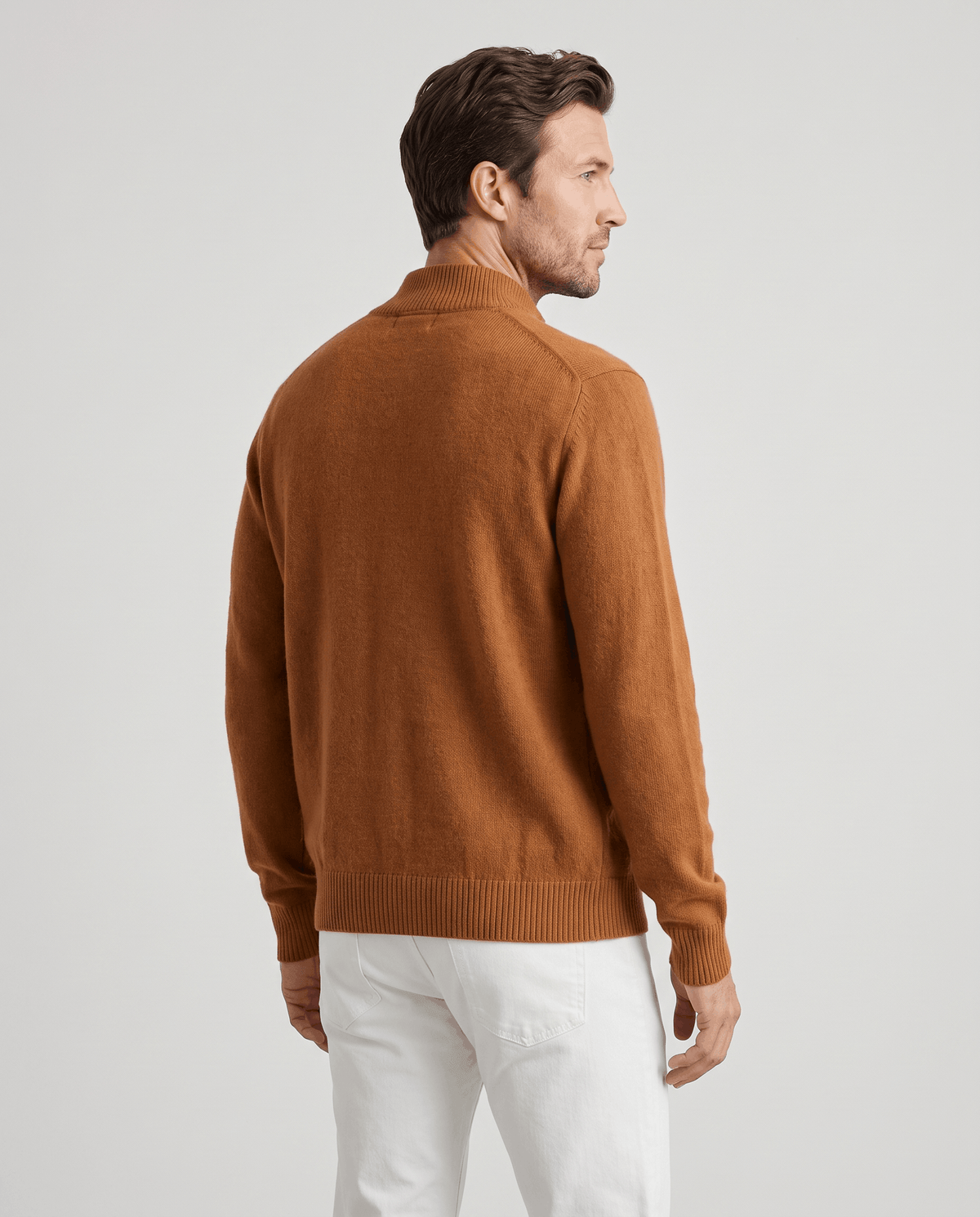 Back view of the orange knit cardigan with white trousers