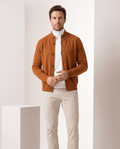 Man wearing an orange merino wool button-front cardigan sweater with beige chinos
