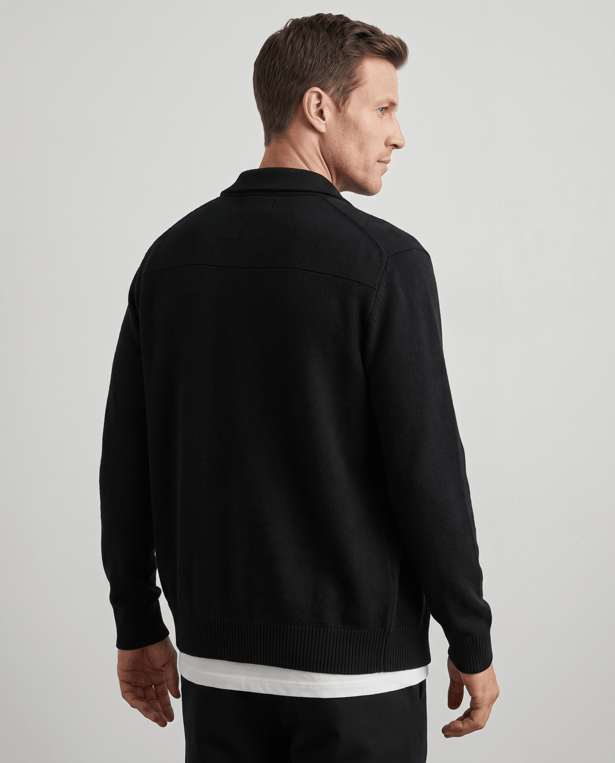 Back view of the black merino zip cardigan with ribbed hem