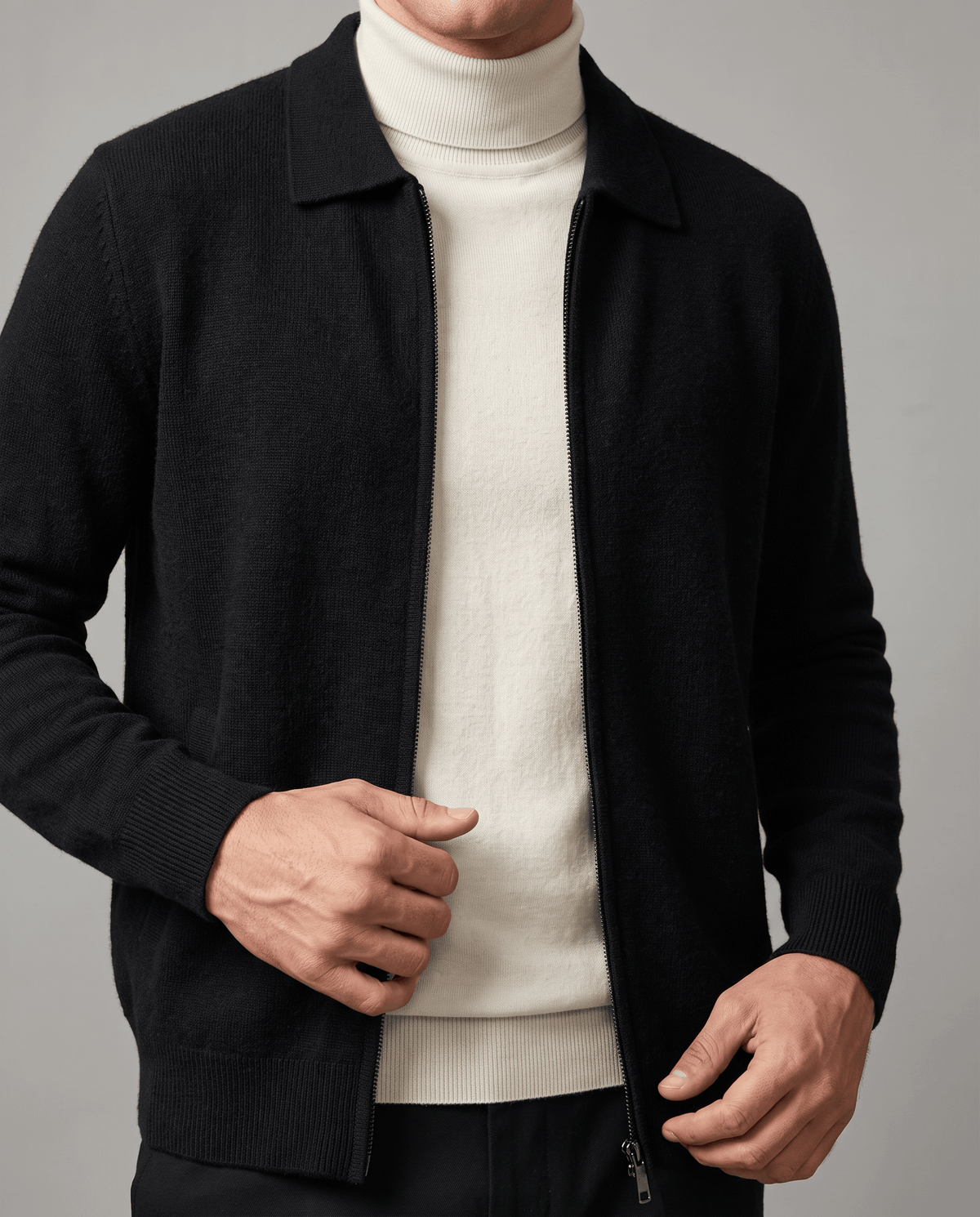 Close-up of the black zip cardigan worn open over a cream turtleneck