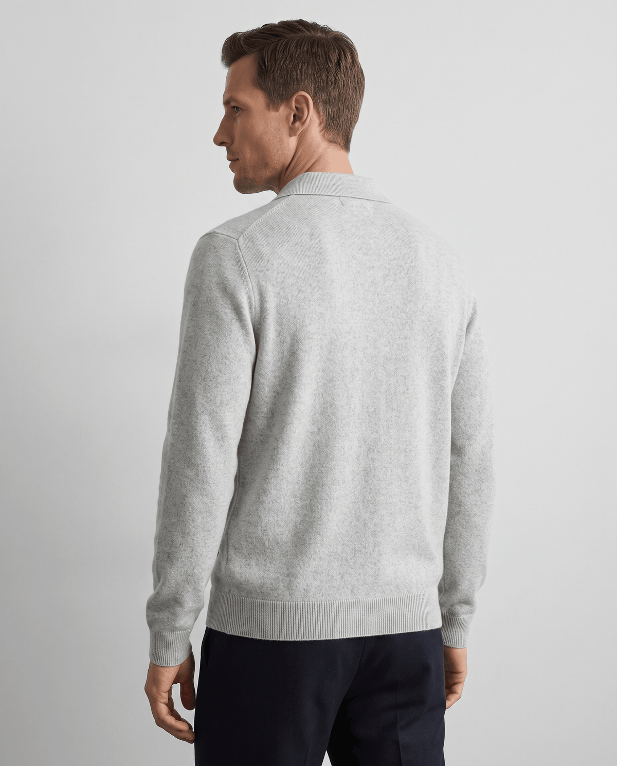 Back view of the light gray zip cardigan with navy trousers