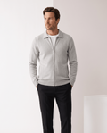Man wearing a light gray merino wool zip-up cardigan with a shirt collar and dark trousers