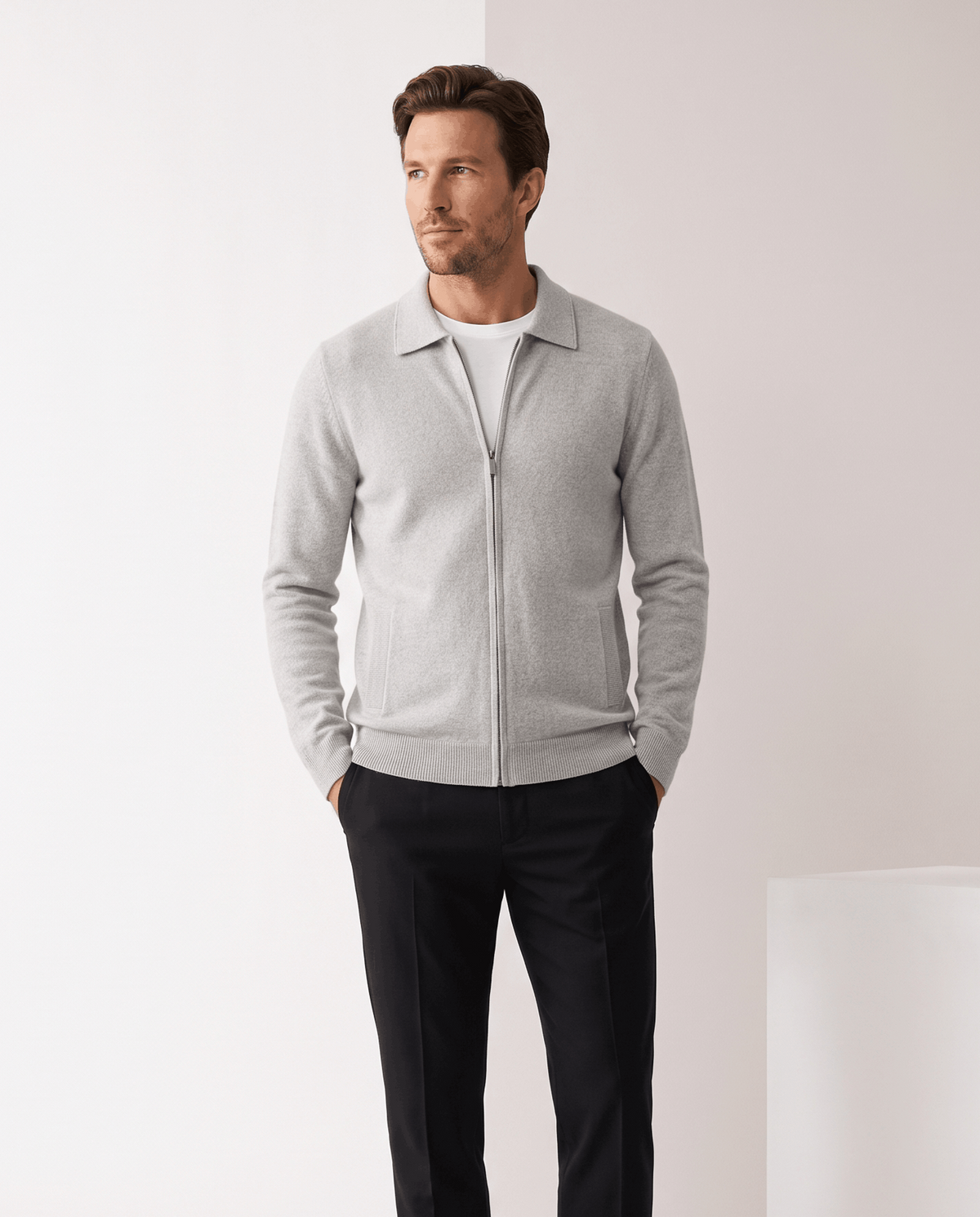 Man wearing a light gray merino wool zip-up cardigan with a shirt collar and dark trousers
