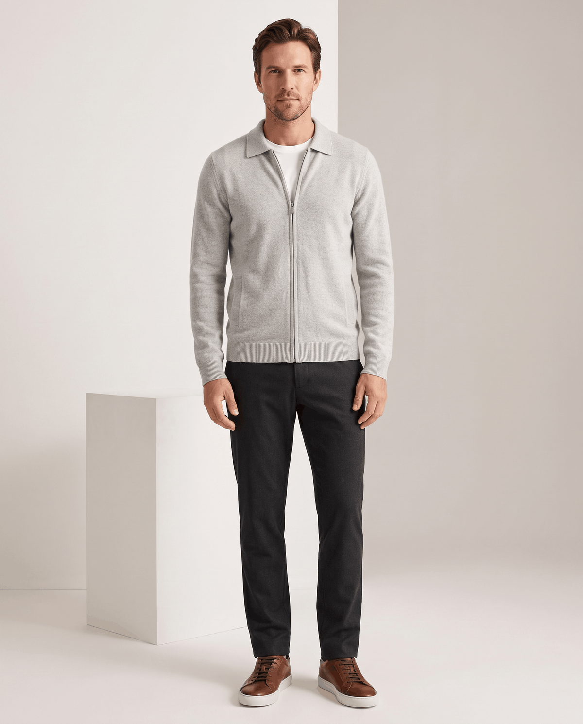 Full-length view of the light gray cardigan with dark trousers and brown shoes