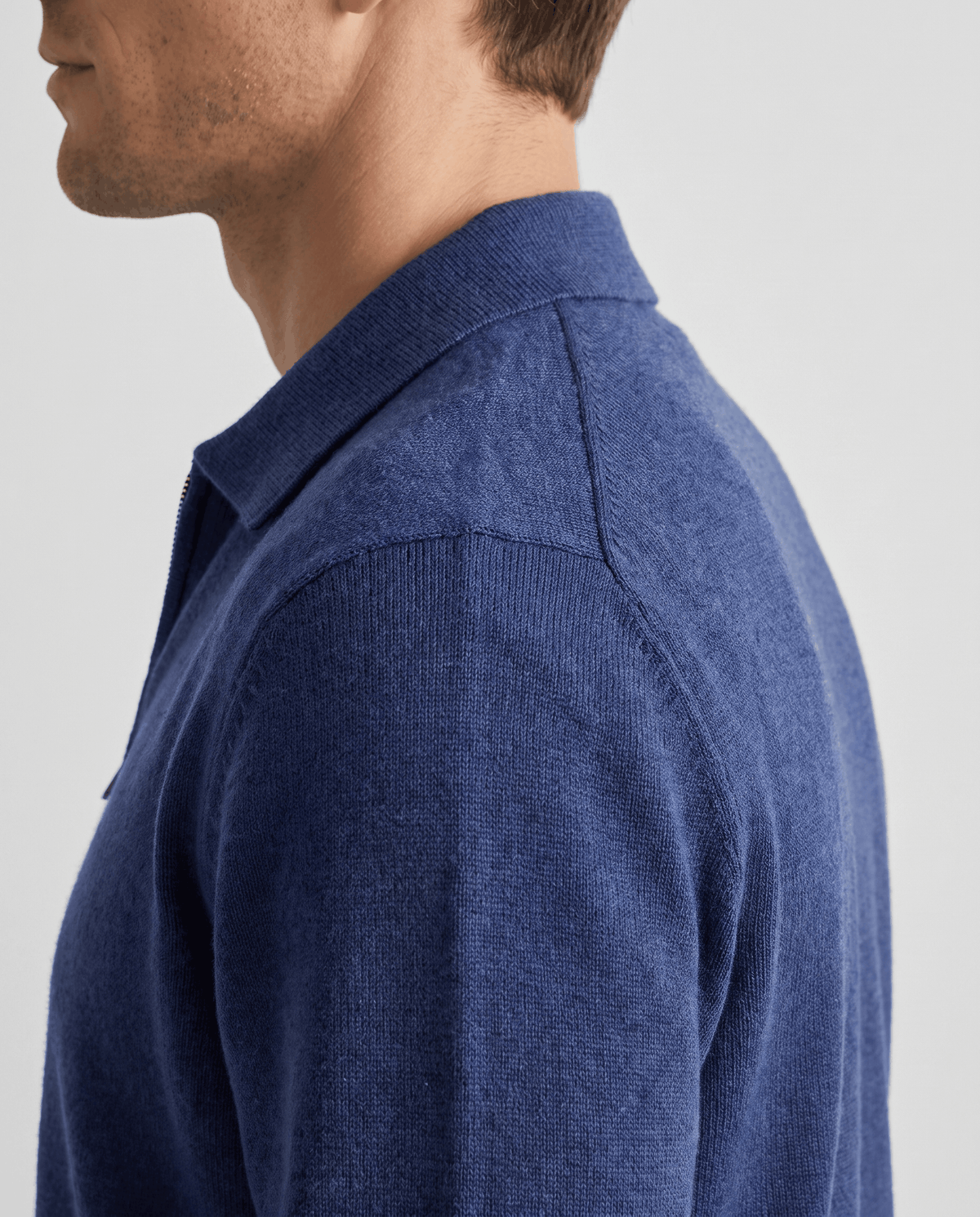 Side profile of the navy cardigan showing the shirt collar and shoulder