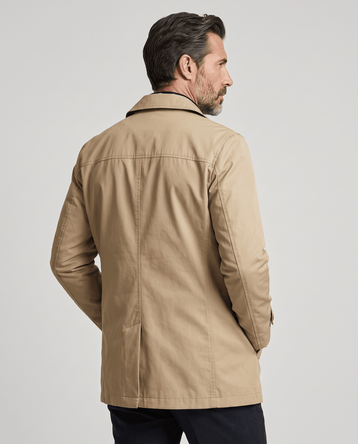 Back view of a beige trench coat showing a straight mid-thigh hem