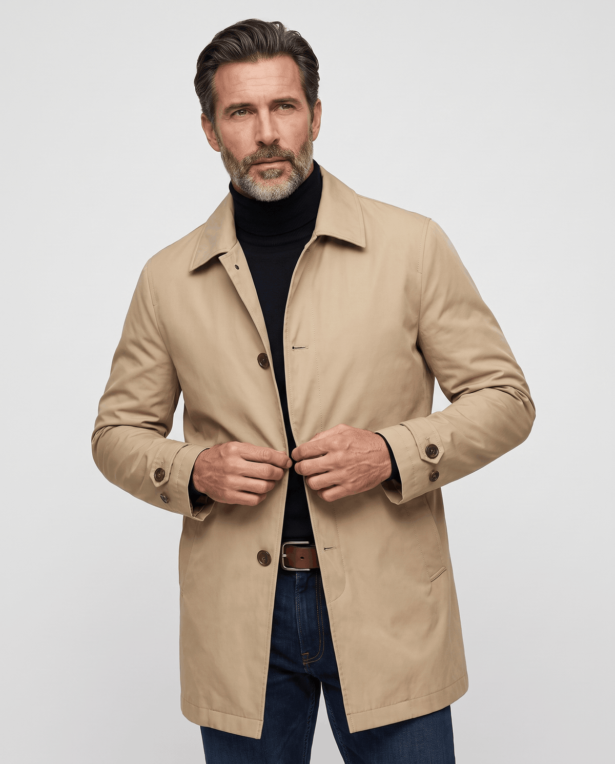Beige trench coat worn buttoned over a black roll-neck sweater