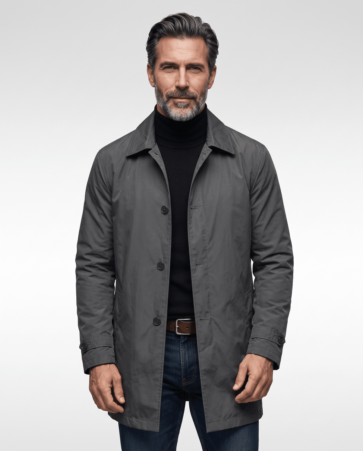 Man wearing a gray mid-length trench coat over a black roll-neck and jeans