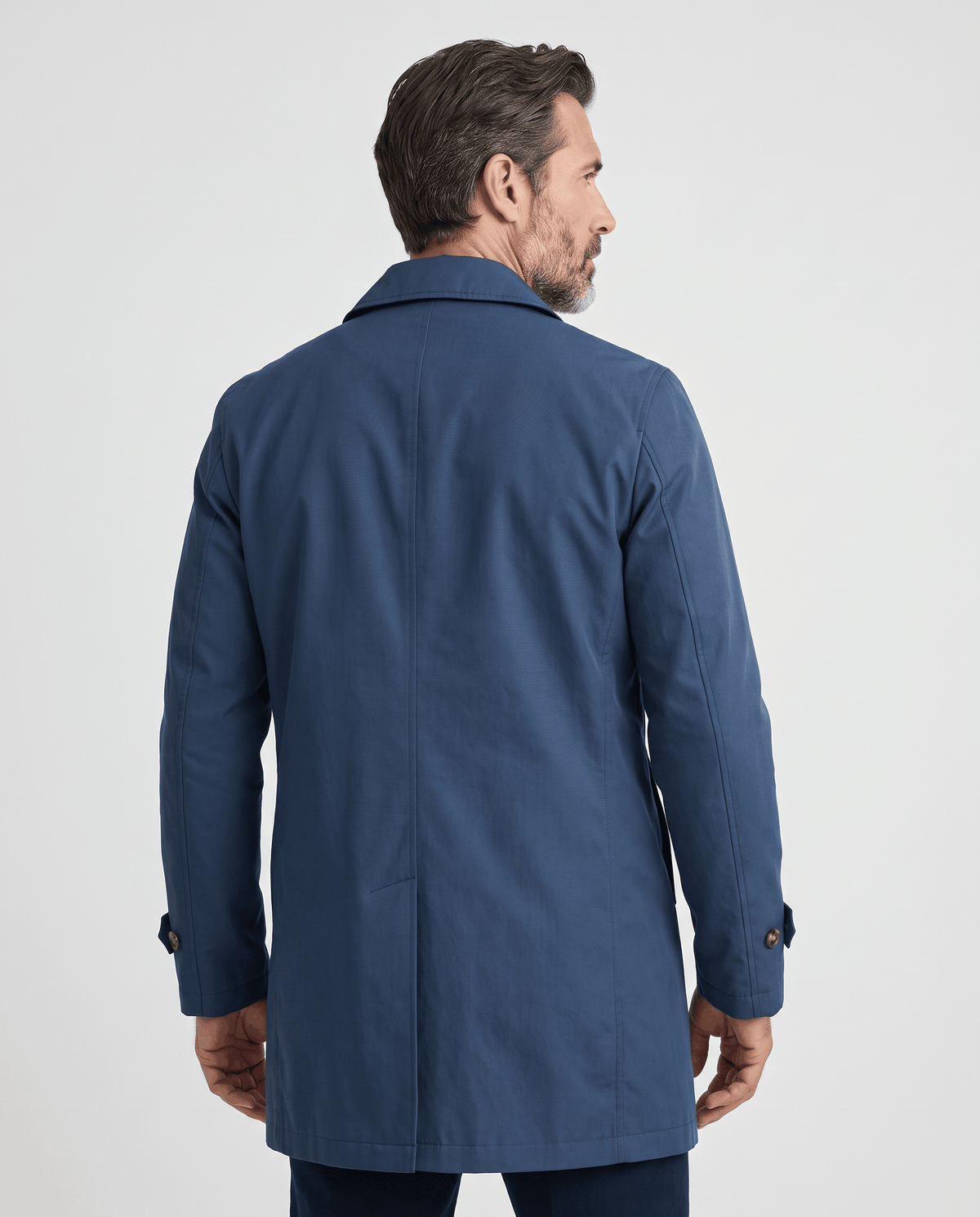 Back view of a navy blue trench coat with buttoned cuff tabs