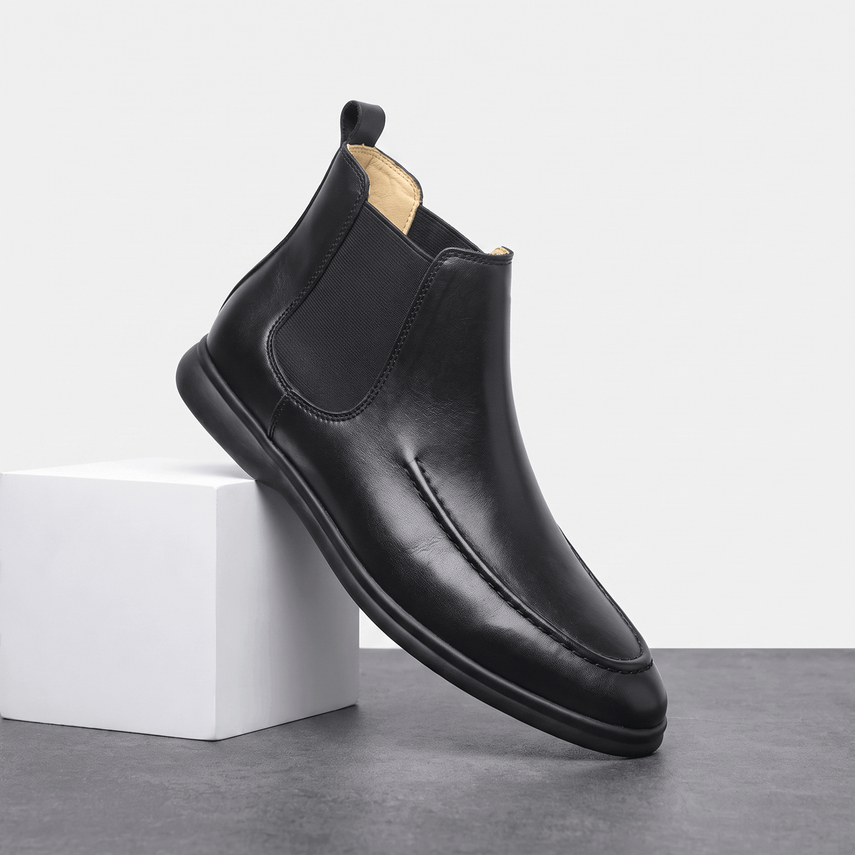 Single black smooth-grain moc toe Chelsea boot with elastic side panels, a pull tab, and a slim cupsole.