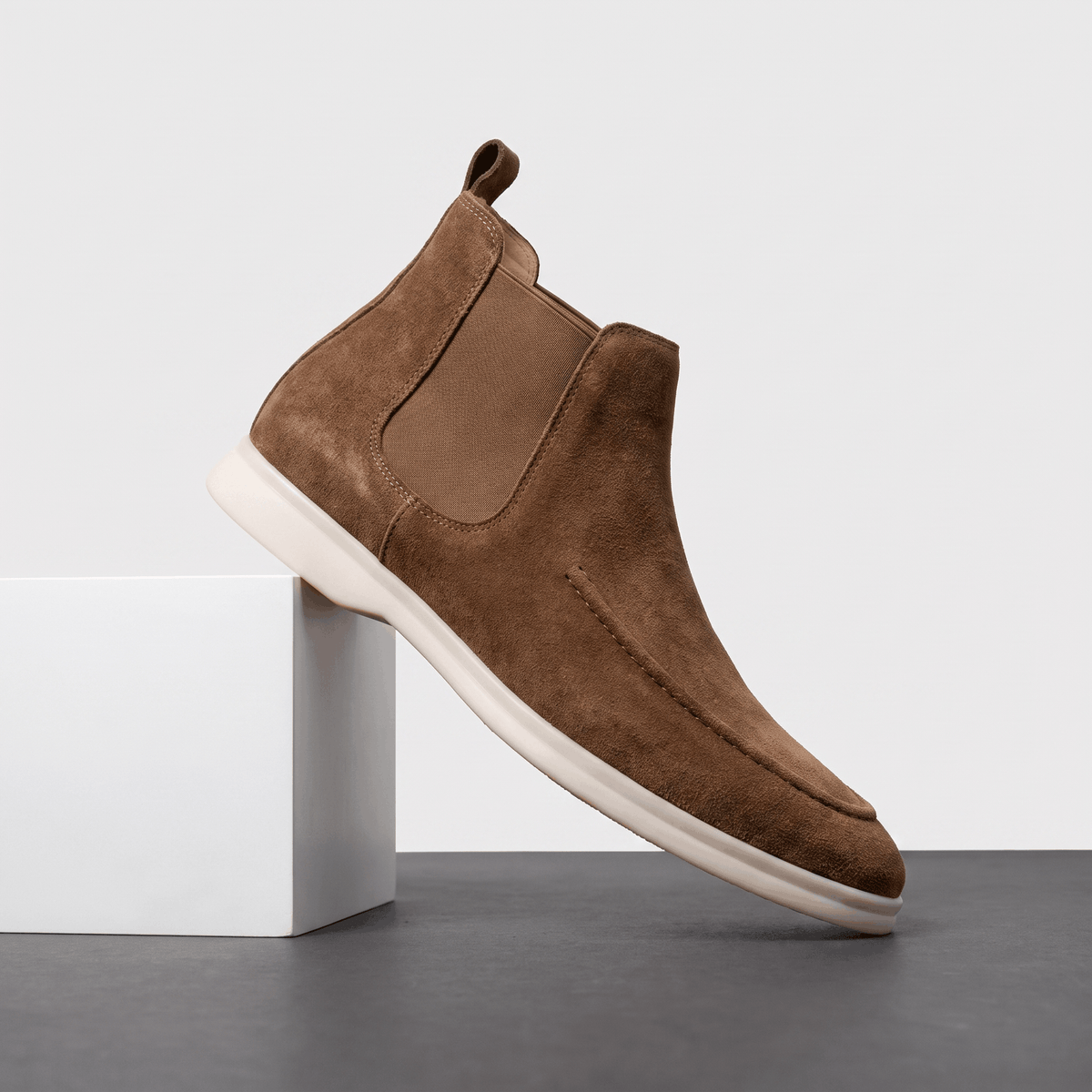 Single brown suede moc toe Chelsea boot with elastic side panels, a pull tab, and a light cupsole.
