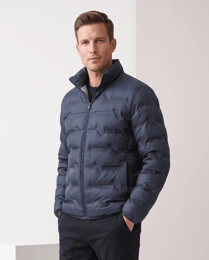 Man wearing a navy blue quilted duck down puffer jacket with stand collar, front view