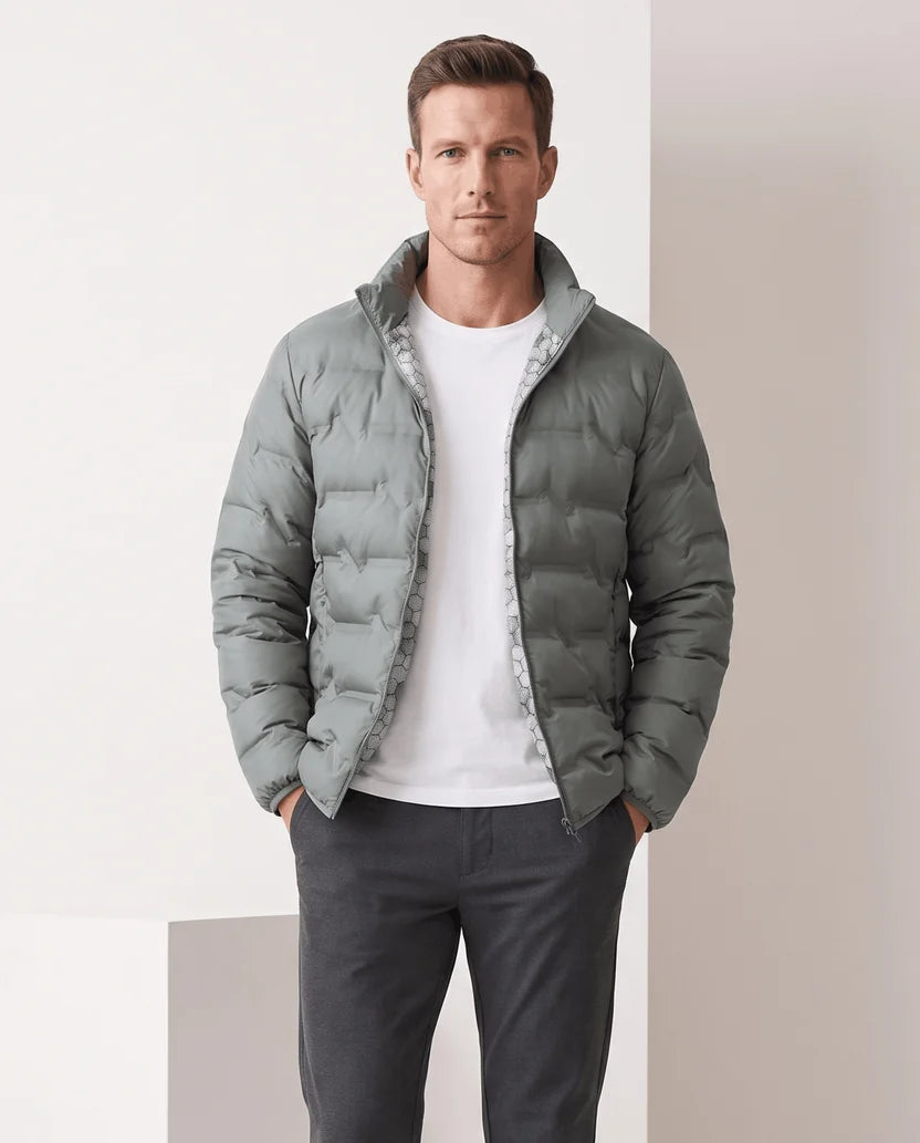 Man wearing an olive green quilted puffer jacket zipped to the stand collar