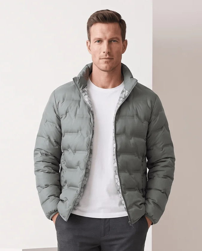 Man wearing an olive green quilted duck down puffer jacket with stand collar, front view