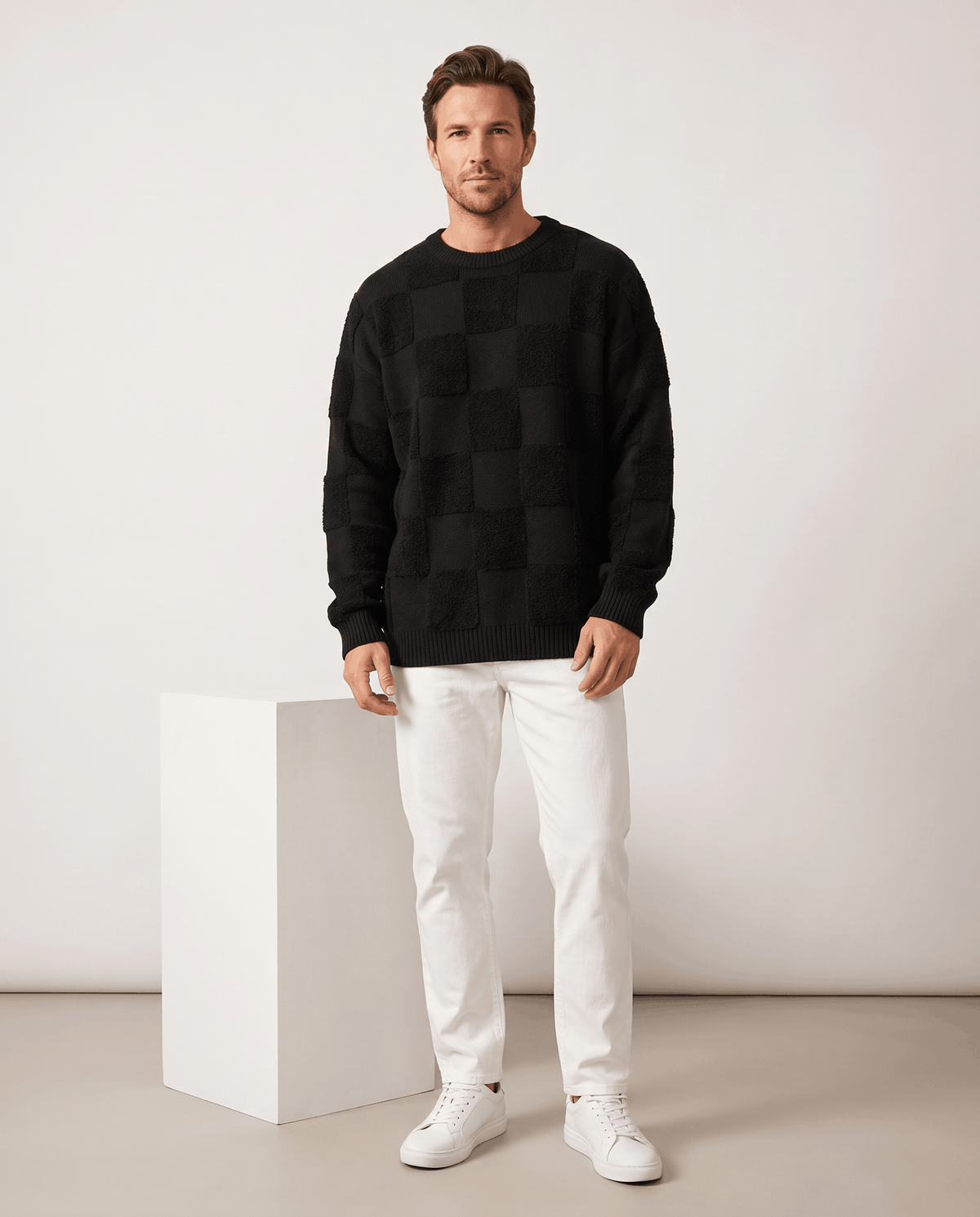 Full-length black checkerboard sweater look with white pants and sneakers