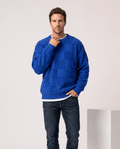 Man wearing men's oversized checkerboard knit sweater in blue with dark jeans